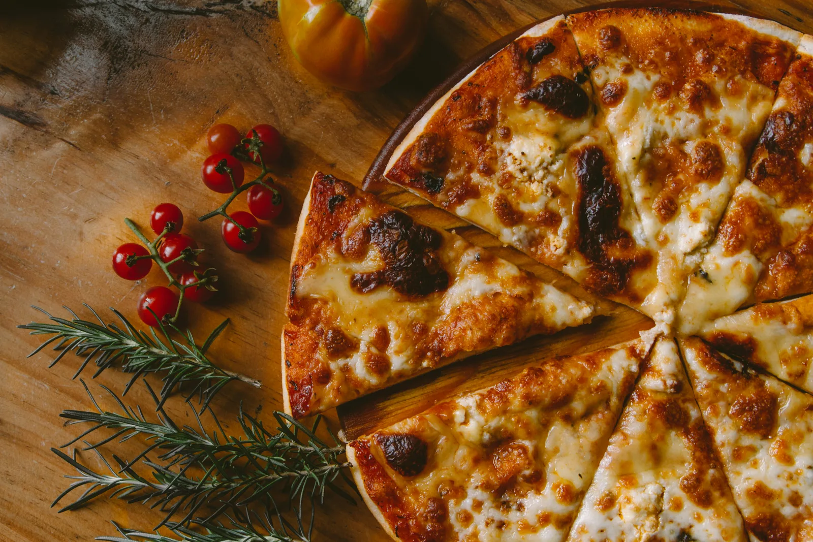 Whole Margherita pizza on a wooden board at Aurenza Web, ready to serve